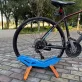   Állítható kerékpár parkoló állvány - Tartós műanyag, padlóra szerelhető kiállító állvány országúti és hegyi kerékpárokhoz biztonságos lábtámasz segítségével Fekete